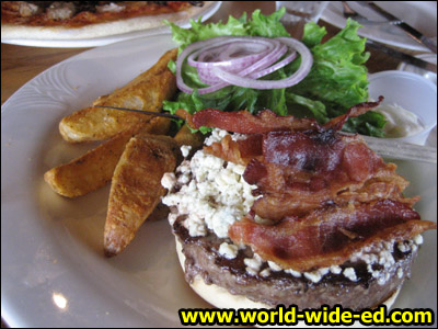 Bacon - Blue Cheeseburger - Smoked bacon and blue cheese cover this 1/2 lb. Black Angus burger charbroiled to perfection and topped with onions, tomatoes and lettuce on a toasted sesame bun. - $13