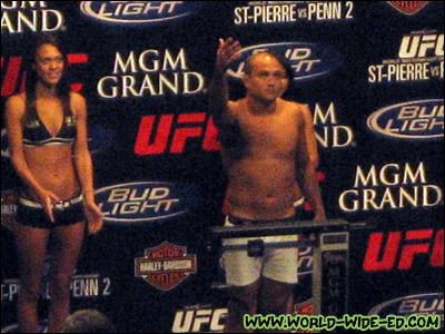 BJ Penn does his King Kamehameha pose while coming in at 168, as ring girls Logan Stanton and Arianny Celeste look on.