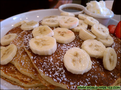 Buttermilk Pancakes with Bananas - 3 light and fluffy pancakes dusted with powdered sugar, served with butter and syrup. Served with bananas, blueberries, caramelized apples or strawberries $1.50 each. ($6.95 + $1.50)
