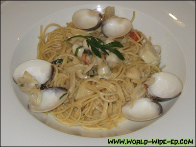 Razor Clam, Bay Scallops and Manila Clam over Noodles entrée - Tender egg noodles, diced tomato, garlic and parsley, tossed in a white wine cream sauce, topped with sautéed razor clam, bay scallops and streamed Manila clams.