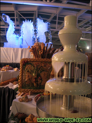 White chocolate fountain with a dragon ice sculpture in the background at the Dessert Extravaganza