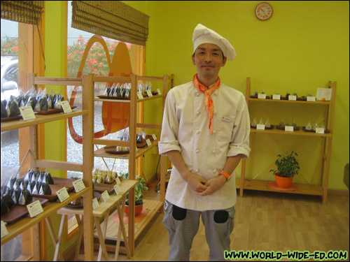 Manabu Asaoka Poses In Front of his Musubi Selection at Mana Bu's