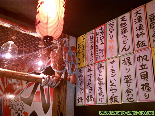 Bright lights, fishing nets, and oshinagaki to the right, inside Izakaya Tairyo