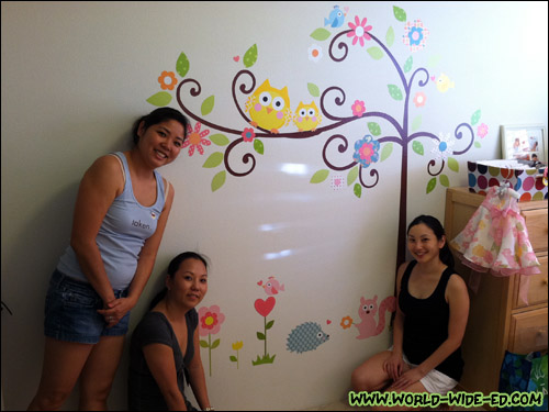 Noele and Shorty help wifey put the decals on baby's bedroom wall